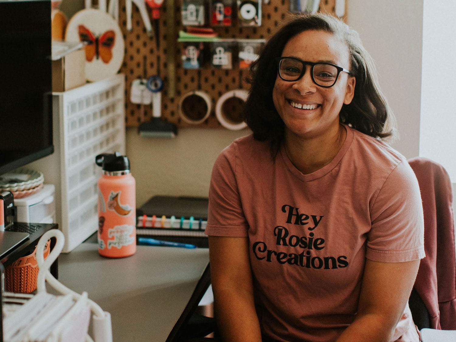 Person wearing a 'Hey Rosie Creations' t-shirt in a workshop setting